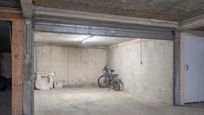 A concrete garage with a bicycle parked inside. - Vue mer et garage privé • Port de Kernével (Larmor-Plage)
