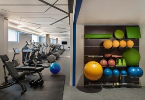 A gym with treadmills, weight machines, and exercise balls.