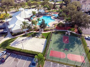 A residential area with a swimming pool, tennis courts, and a parking lot. - Coconico Retreat At Windsor Palms (Kissimmee)