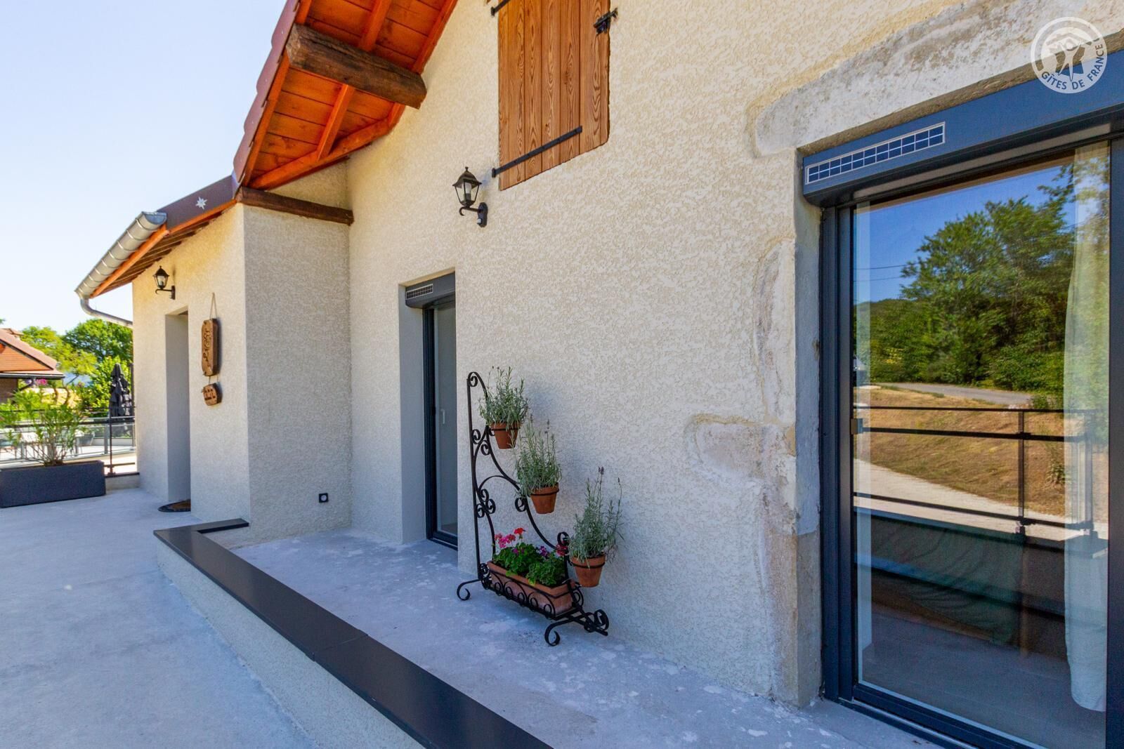 A building with a modern facade, a wooden door, and a window with a view of greenery.