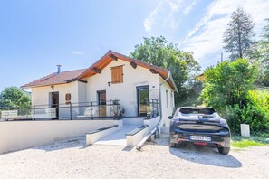 Ein zweistöckiges Haus mit Kiesweg und einem geparkten Auto.