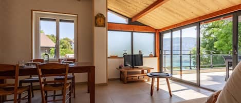 Un comedor con una mesa y sillas de madera, un televisor y un sofá.