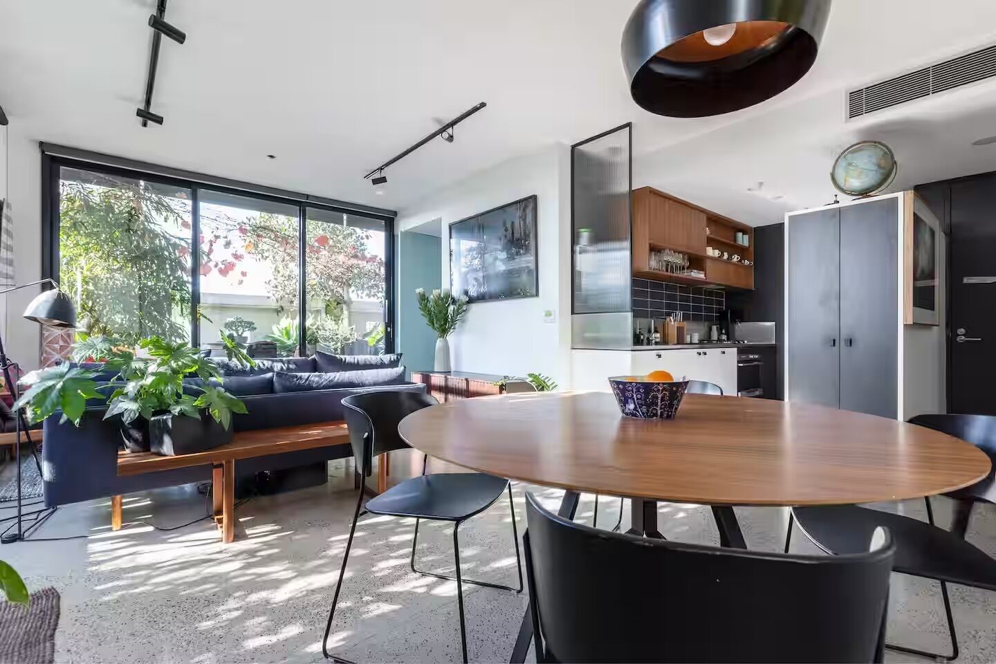 Un espacio de estar moderno con comedor, sofá y cocina.