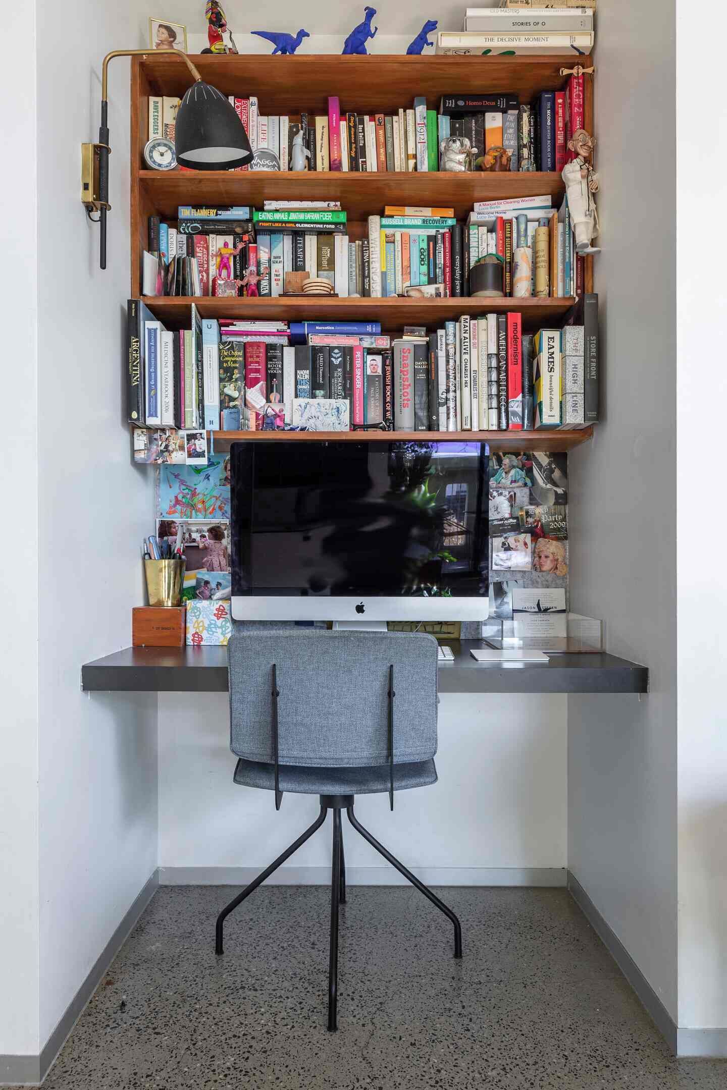 A home office setup with a desk, computer, and a bookshelf filled with books.