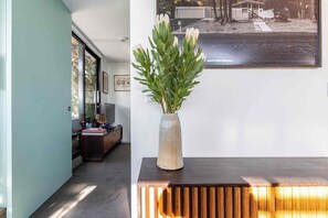 A modern interior with a wooden console table, a vase with flowers, and a framed photograph on the wall. - Private balcony garden oasis in the heart of Fitzroy (Fitzroy)