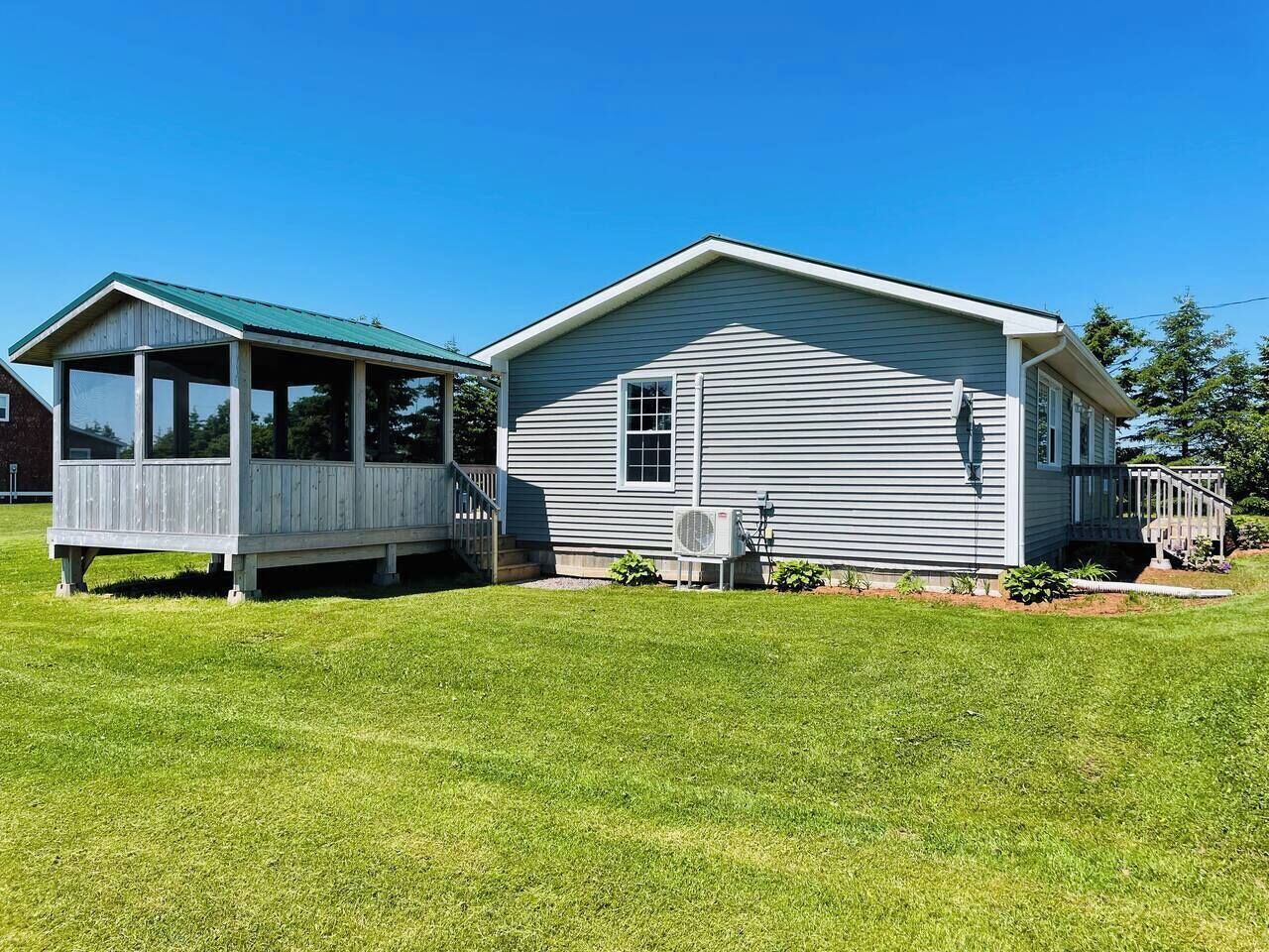 A two-story house with a covered porch and a small detached structure.