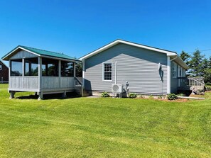 A two-story house with a covered porch and a small detached structure. - The Sea Drift by MemoryMakerCottages by the Beach! (Kensington)