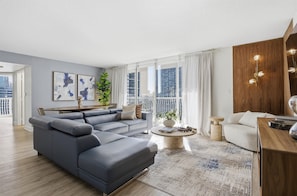 Una sala de estar moderna con un sofá modular, una mesa de centro redonda y vistas de la ciudad.