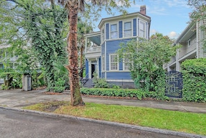 A residential building with a two-story structure, a front porch, and a fenced yard. - 4 Blocks from King St., 3 BR, 2 BA with a porch and 1 parking spot (Charleston)
