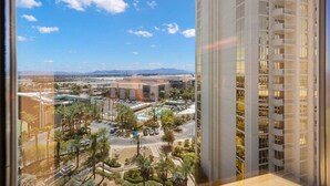A high-rise hotel with a view of a parking lot, pool, and distant mountains. - On LV Strip + Resort Access / Signature MGM (Las Vegas)