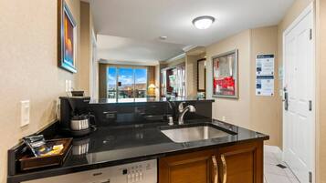 A hotel kitchen with a Bosch dishwasher, a coffee maker, and a sink.