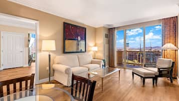 Un salon spacieux comprenant un canapé, des fauteuils, une table basse et une table à manger.