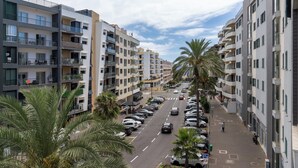 A multi-story residential building with balconies, a parking lot, and palm trees. - Ajuda VI – Comfortable Apartment in Funchal (Funchal)