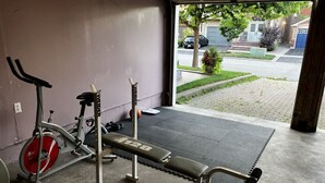 Ett gym med en bänkpress, en motionscykel och en viktbänk.