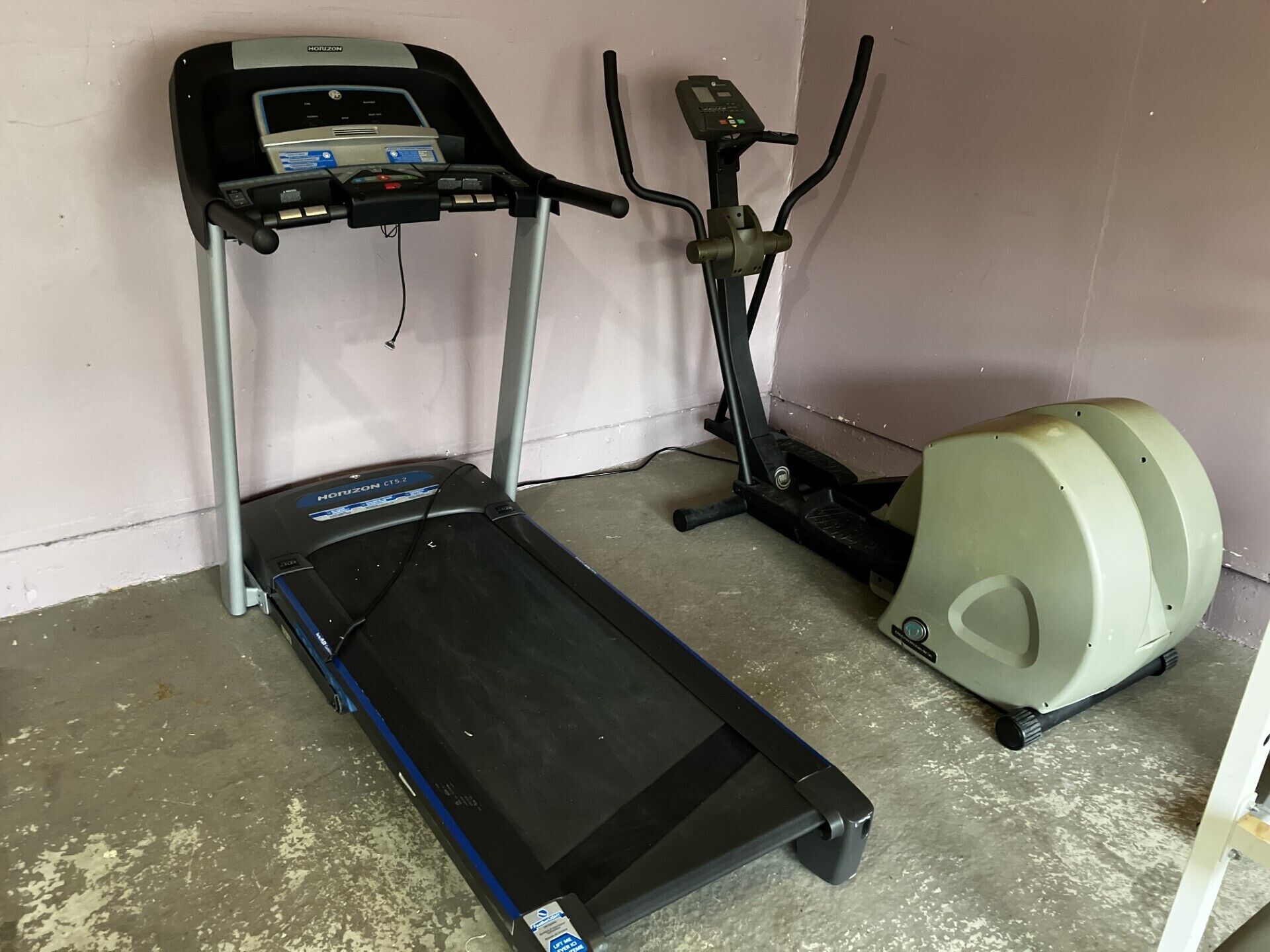 A home gym with a treadmill, elliptical, and stationary bike.