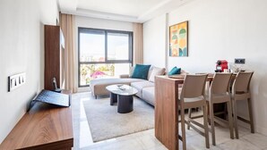 Una sala de estar moderna con sofá, mesa de centro y comedor con sillas.