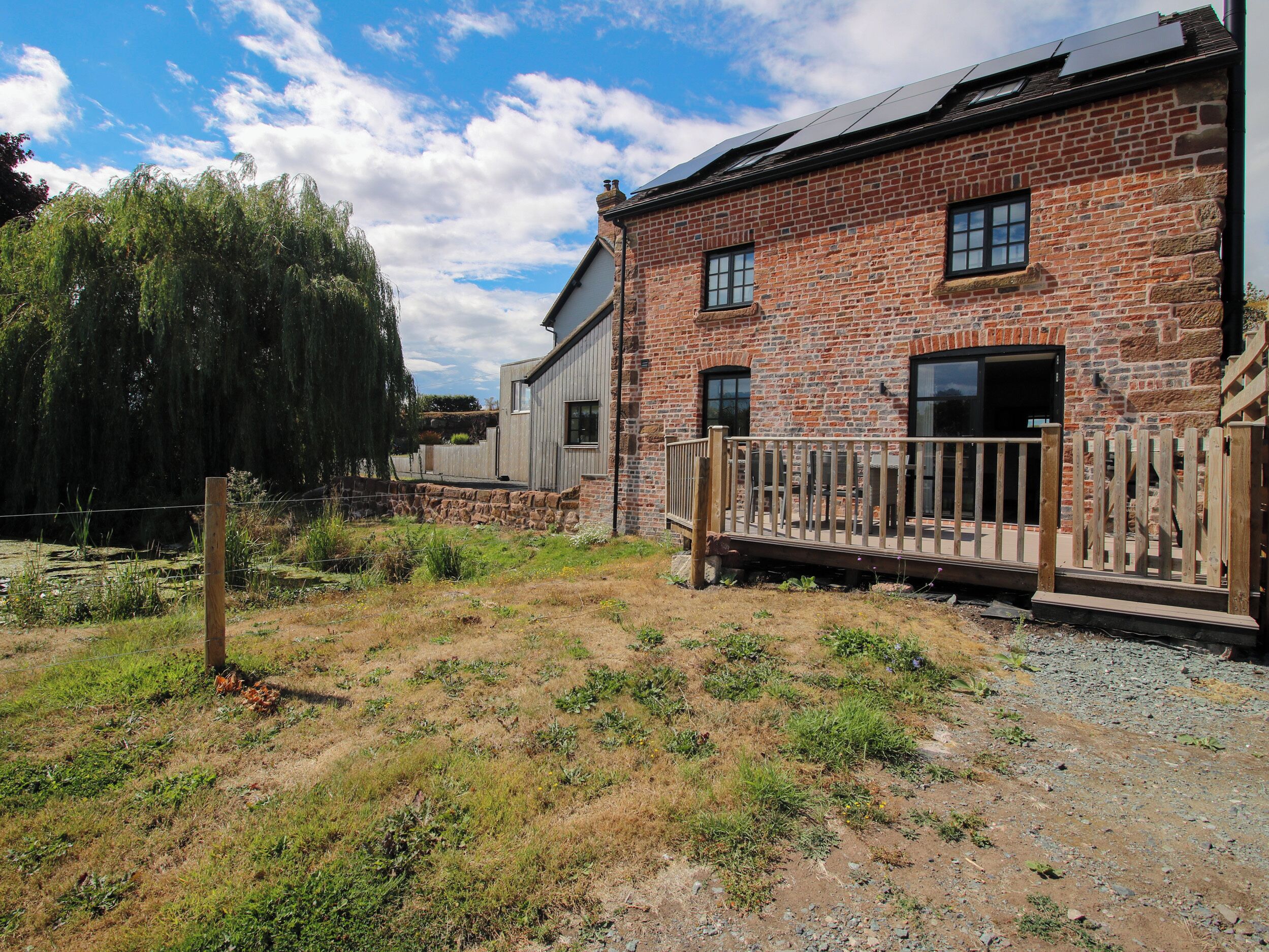 A brick building with a wooden deck and a stone wall.