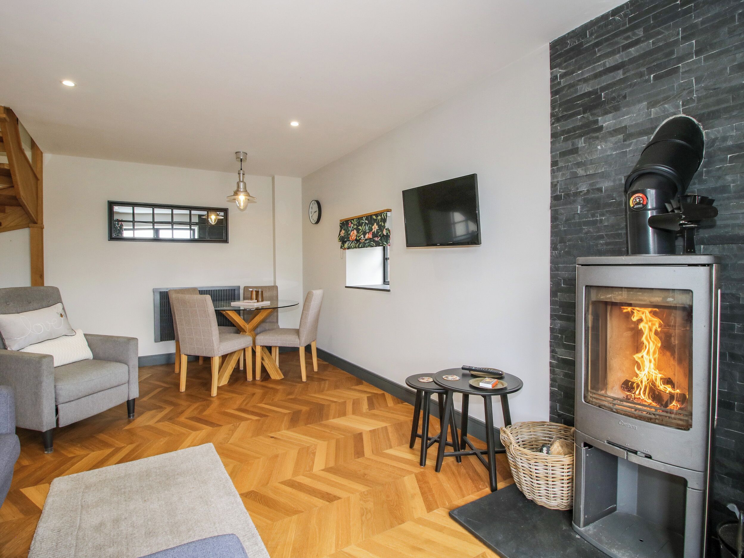 A cozy living room with a fireplace, a dining area with a table and chairs, and a comfortable seating area.