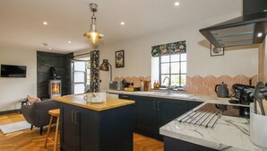 A modern kitchen with a central island, built-in appliances, and a large window. - The Old Mill (Telford)