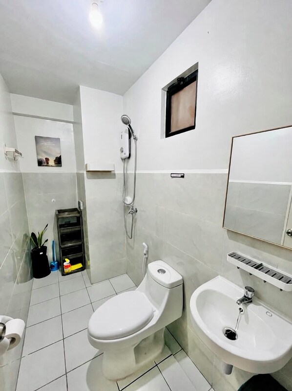 A modern bathroom with a toilet, bidet, and sink.