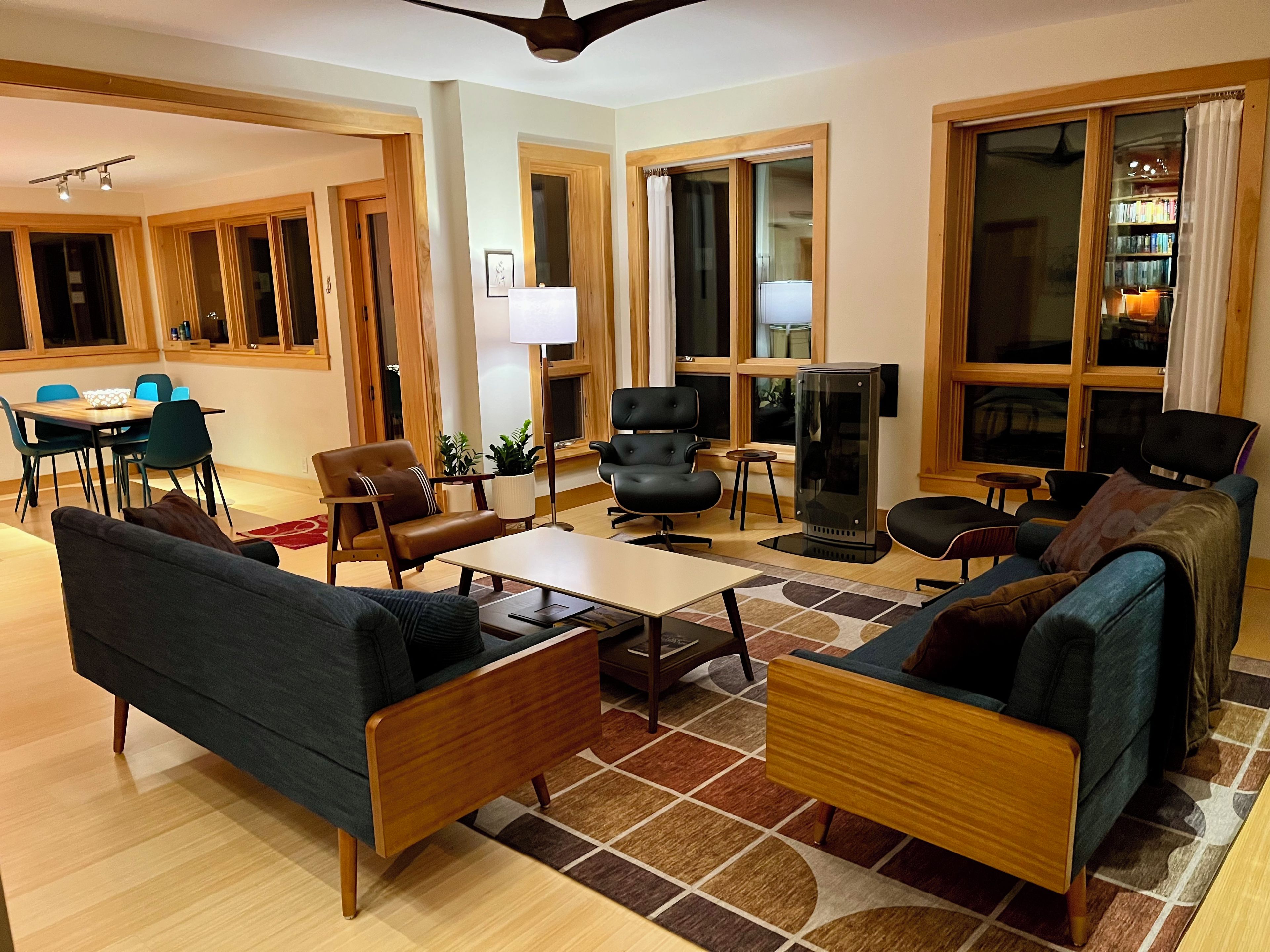 A modern living room with a sofa, armchairs, a coffee table, and a fireplace.