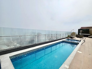 A rooftop swimming pool with a glass barrier and a view of the cityscape. - Barranco Luxe | A/C • Rooftop Pool & Hot Tub • Gym ⭐ (Barranco)