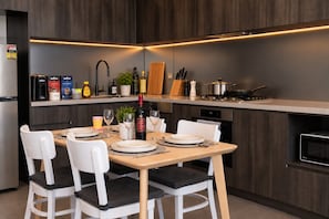 Cozinha moderna com área de refeições, equipada com fogão, pia e diversos eletrodomésticos.