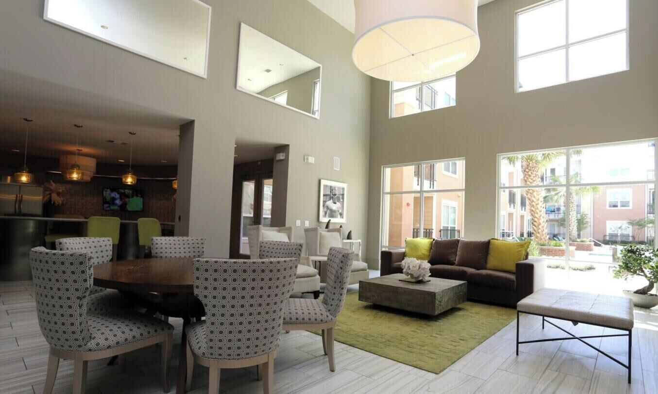 A spacious living area with a dining set, a sofa, and a coffee table.