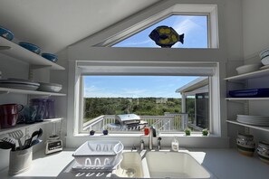 A kitchen with a large window, a sink, and various kitchen utensils. - Gorgeous Family Rental - Steps to Sagamore Beach (Sandwich)
