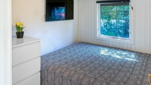 A room with a bed, a television, a window, and a plant. - Awesome home in Jægerspris with WiFi (Jægerspris)