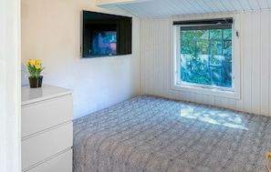 A room with a bed, a television, a window, and a plant. - Awesome home in Jægerspris with WiFi (Jægerspris)