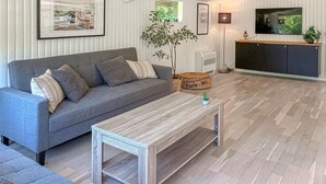 A living room with a grey sofa, a coffee table, a television, and a plant. - Awesome home in Jægerspris with WiFi (Jægerspris)
