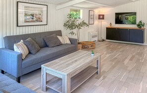A living room with a grey sofa, a coffee table, a television, and a plant. - Awesome home in Jægerspris with WiFi (Jægerspris)