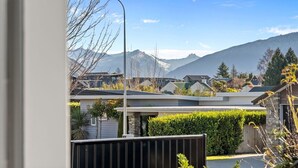 Ein Wohngebiet mit modernen Häusern, einer Straßenlaterne und Bergen im Hintergrund.