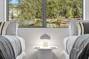 A room with two striped sofas facing a window overlooking a natural landscape. - Family Ski Base | Boot Dryer | 4Bedroom (Wānaka)