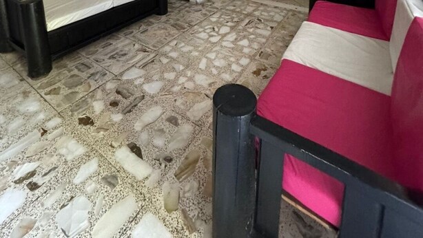 Une pièce avec un escalier, un canapé, un lit et une petite table.