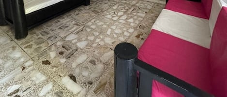 Una habitación con escalera, sofá, cama y una pequeña mesa.
