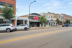 A street view with a restaurant named 'TWO' featuring pizza, beef, and whiskey.