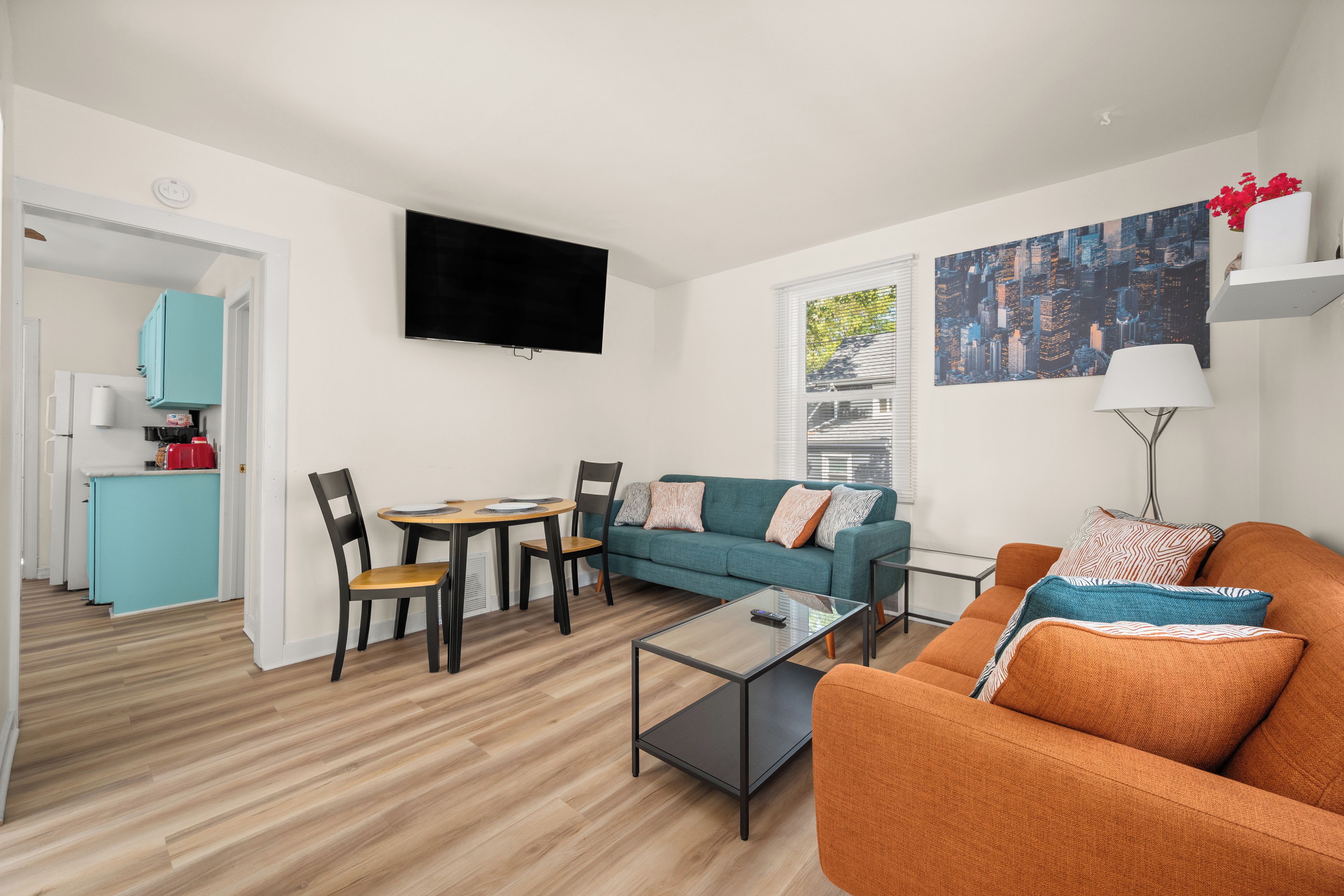A modern living room with a sofa, a coffee table, and a TV mounted on the wall.