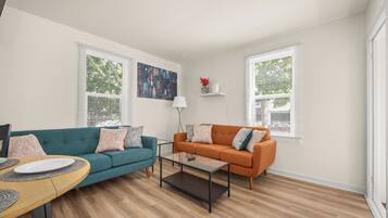 A living room with two sofas, a coffee table, and a painting on the wall.