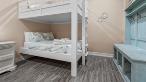 Ein Stockbett mit weißem Gestell, ein Nachttisch und eine Kommode in Hellblau.
