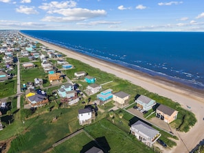 An aerial view of a coastal residential area with houses, a beach, and the ocean. - Beachfront Home in Crystal Beach | Private Hot Tub | Double Decks | Outdoor Bar | Sleeps 16 (Crystal Beach)
