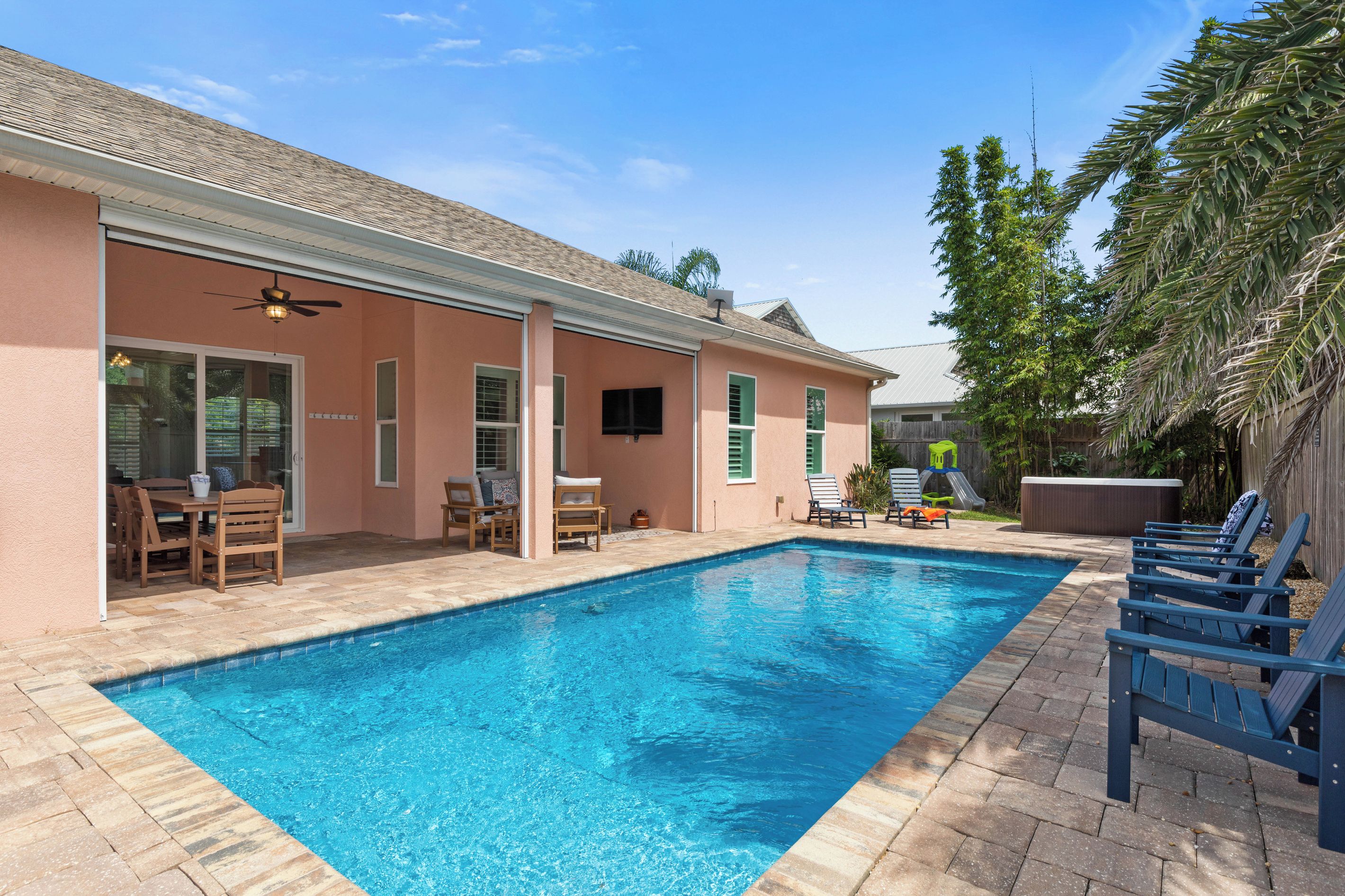 Une piscine avec des chaises longues et un espace patio.