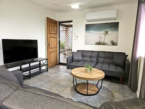 A living room with a TV, sofa, and a round coffee table.