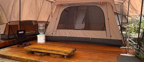 Una carpa con una terraza de madera y zona de estar.