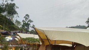 A row of tents with attached awnings, wooden flooring, and outdoor seating areas. - Cozzy Bantaran Riverside (pangalengan)