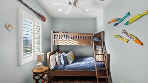 A bunk bed with a ladder, a window with blinds, a lamp, and decorative fish wall art. - Chasing Sunshine by Avantstay Shared Pool + Gazebo + Covered Patio Walk to the Beach (Port Aransas)