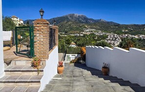 A staircase leading to a terrace with a view of a mountain and a town. - Cozy home in Viñuela with private swimming pool, can be inside or outside (Viñuela)