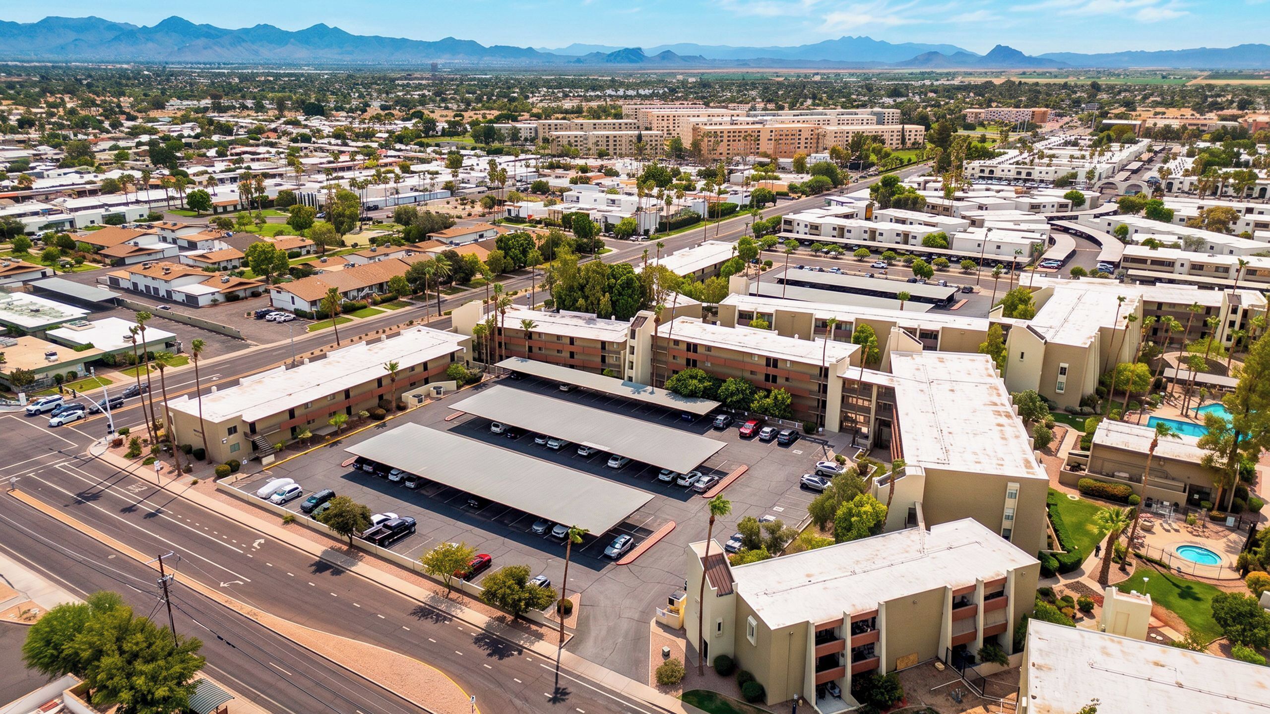 An aerial view of a commercial area with multiple buildings, roads, and parking lots.