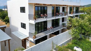 Un immeuble moderne à plusieurs étages, doté de balcons, de grandes fenêtres et d’un toit plat.